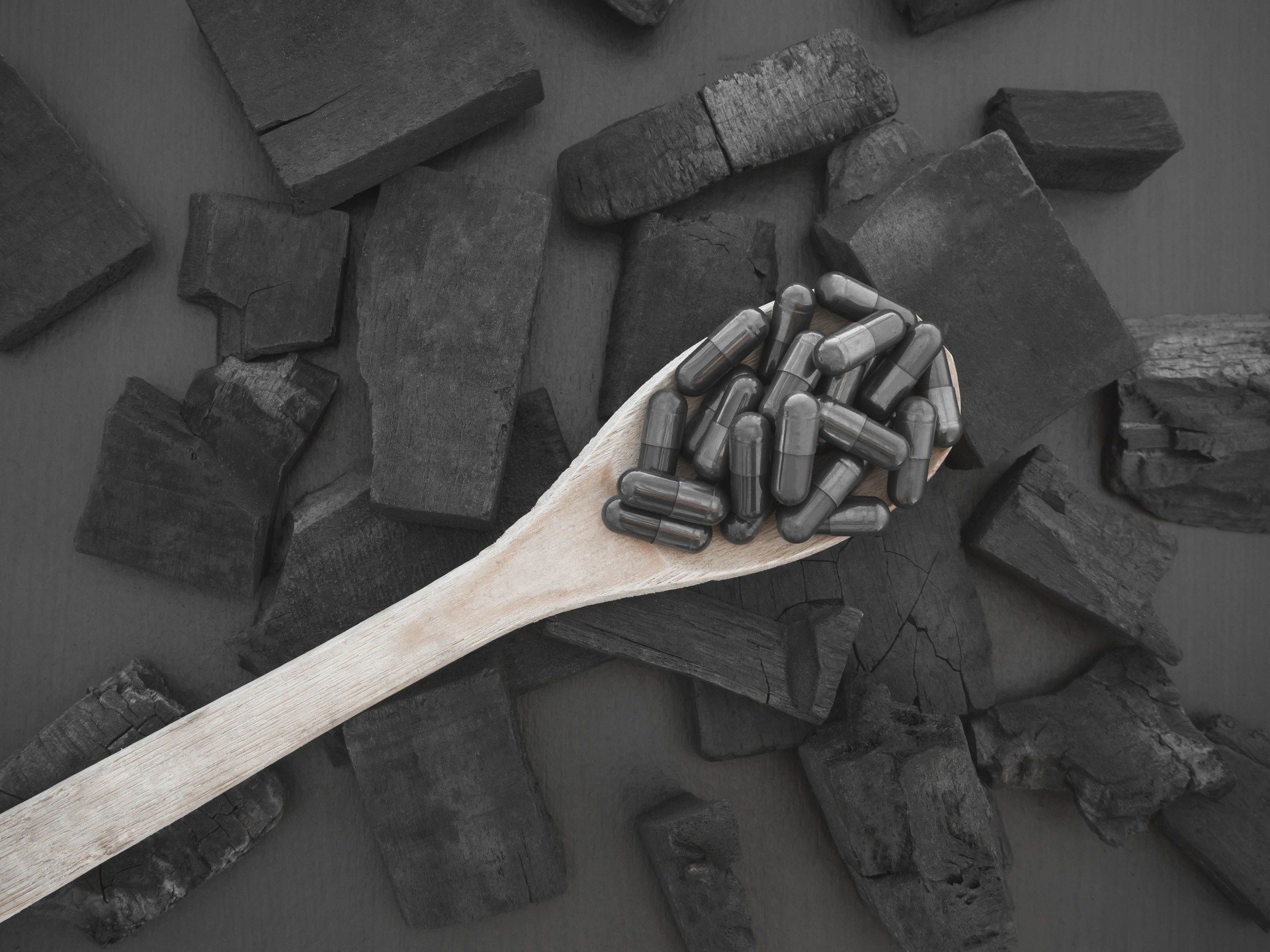 Charcoal capsule and charcoal on black background for for to cure diarrhea and Absorb toxins in the intestine.